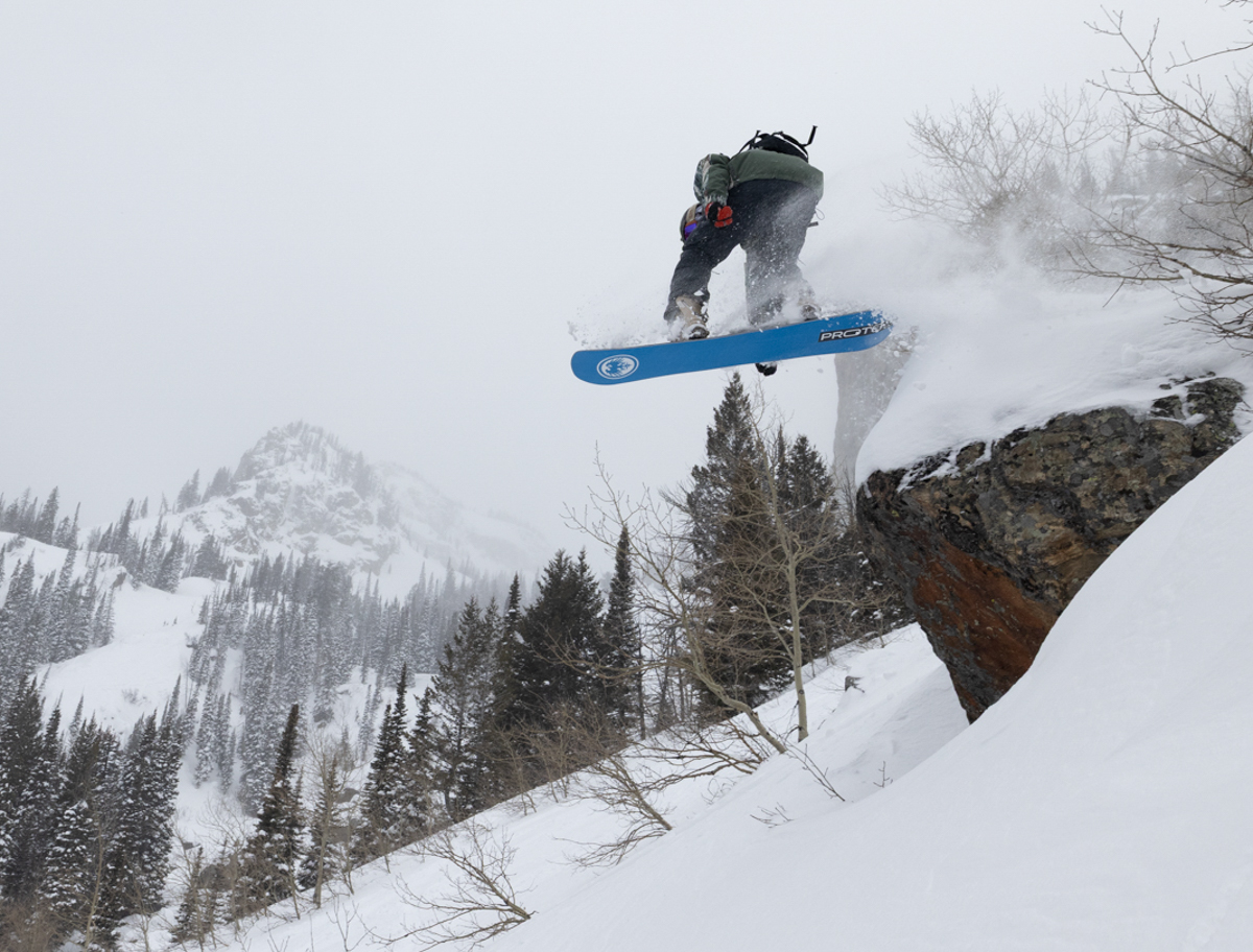 Snowboarder catching air off a natural feature in Jackson Hole testing Union Atlas bindings.