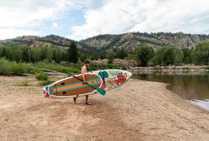 Man Walking with Paddle Board