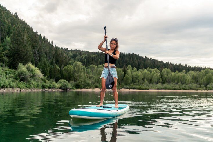 Women Paddleboarding on Glassy Water
