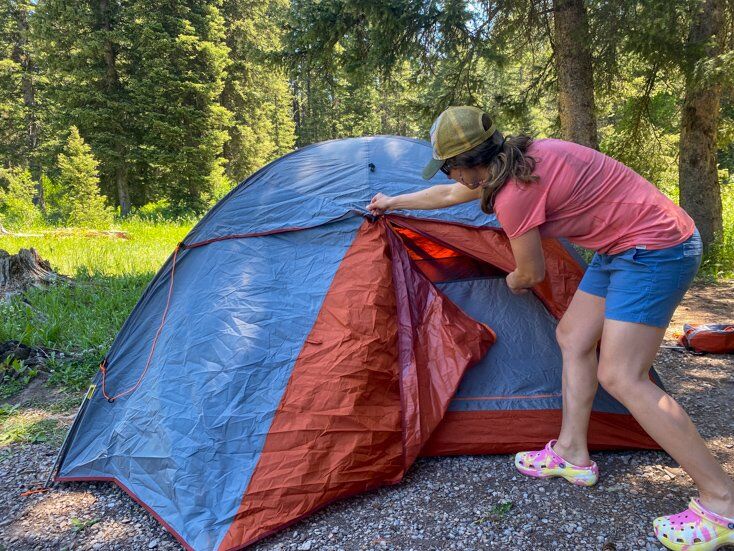 Women Unzipping Tent While Camping