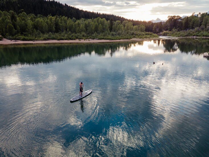Drone Shot of Paddle Boarder With Water Reflecting