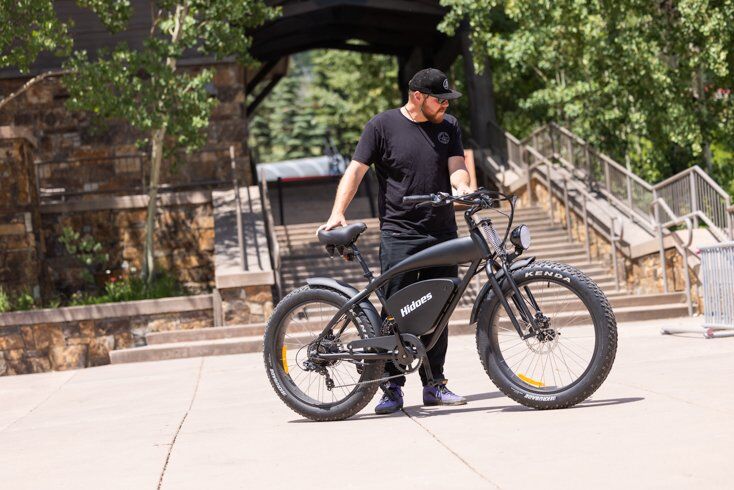 Large Man Standing Next to Hidoes B3 E-Bike Frame