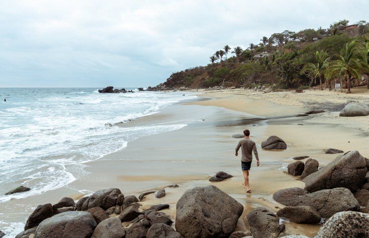 Man Walking on Beach in