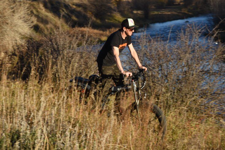 Man Riding E-Bike Next to Stream