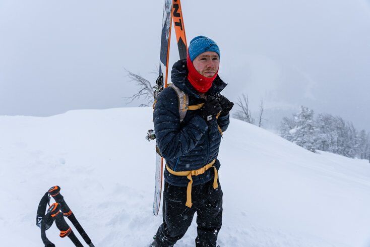 Man Wearing Puffy Jacket Atop Mountain