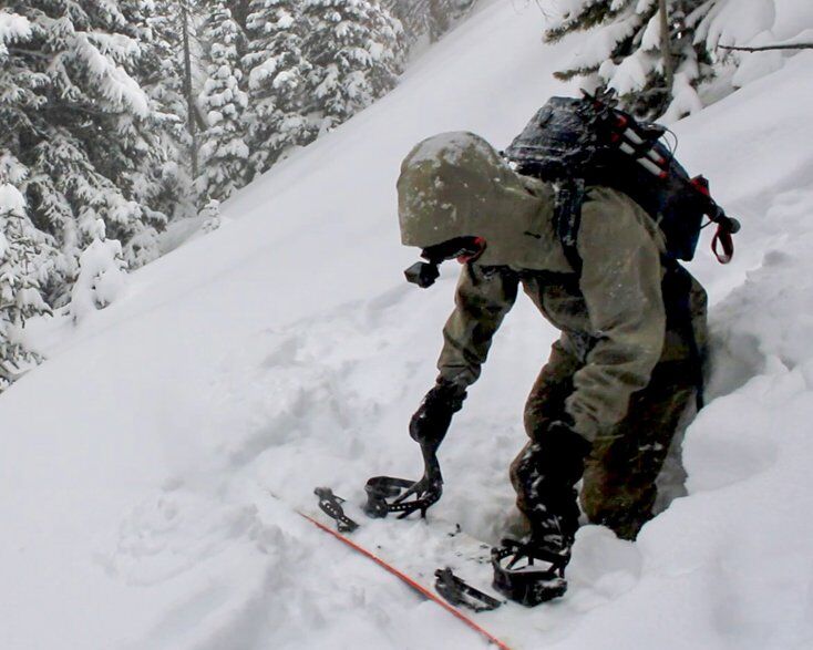 Man Strapping into Snowboard