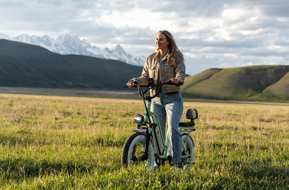 Women Standing Next to E-Bike with Sun in Background