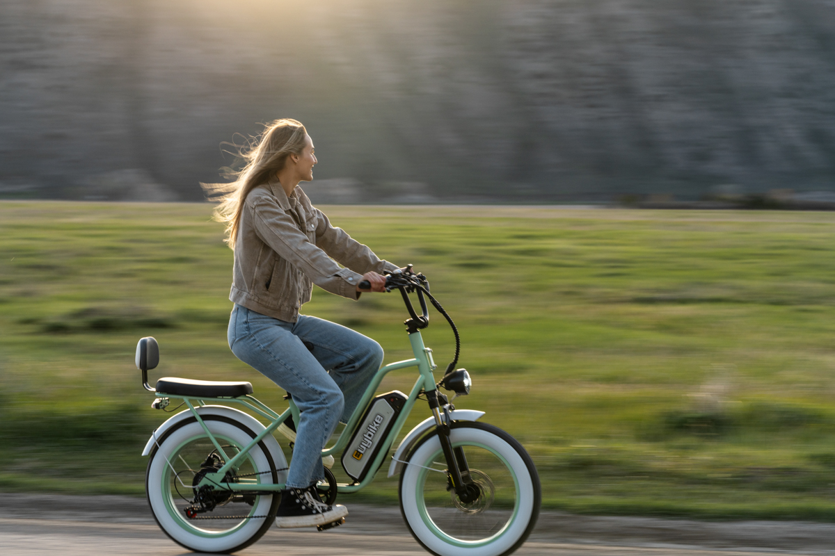 Women Riding E-Bike with Blond Hair and Summer Sun