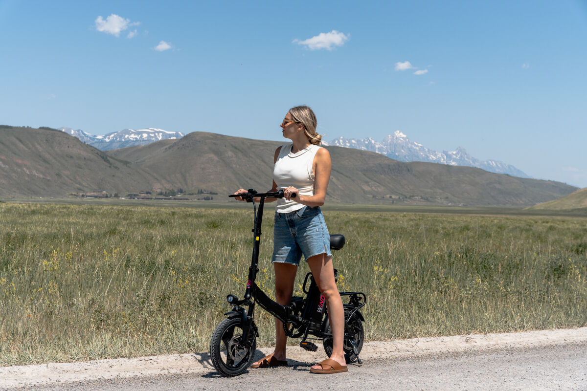 Women Standing Next to E-Bike on Gravel Road