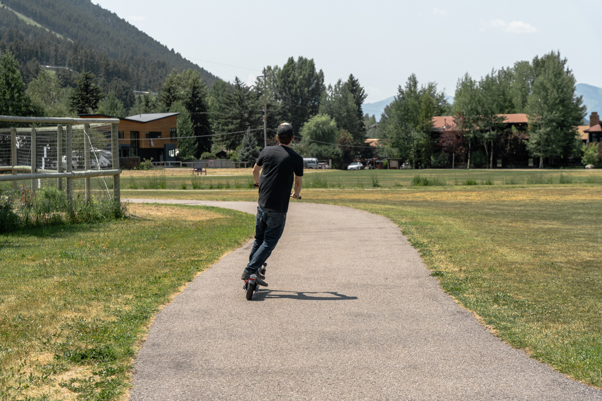 Man Riding E-Scooter on Bike Path