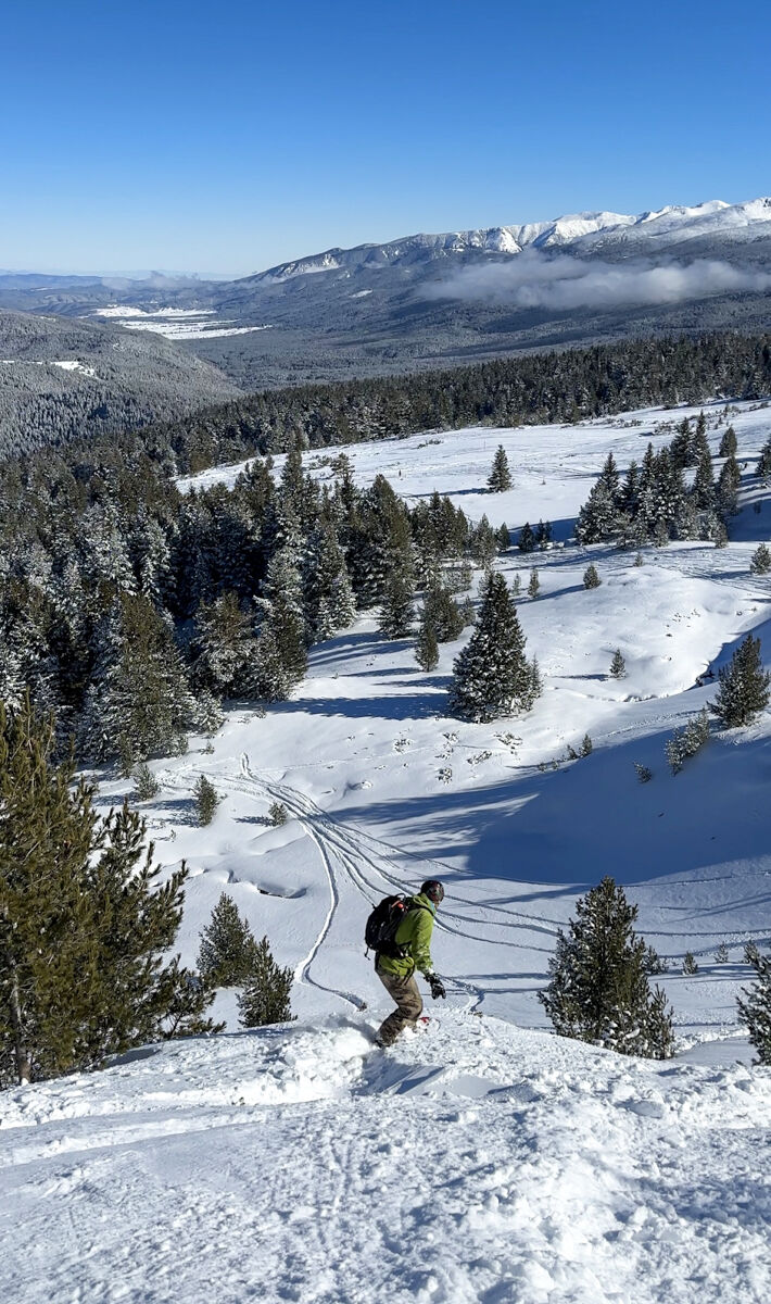 Forest adventures await. Pictured here - Kiril Zahov about to cliff drop into some bluebird powdery turns.