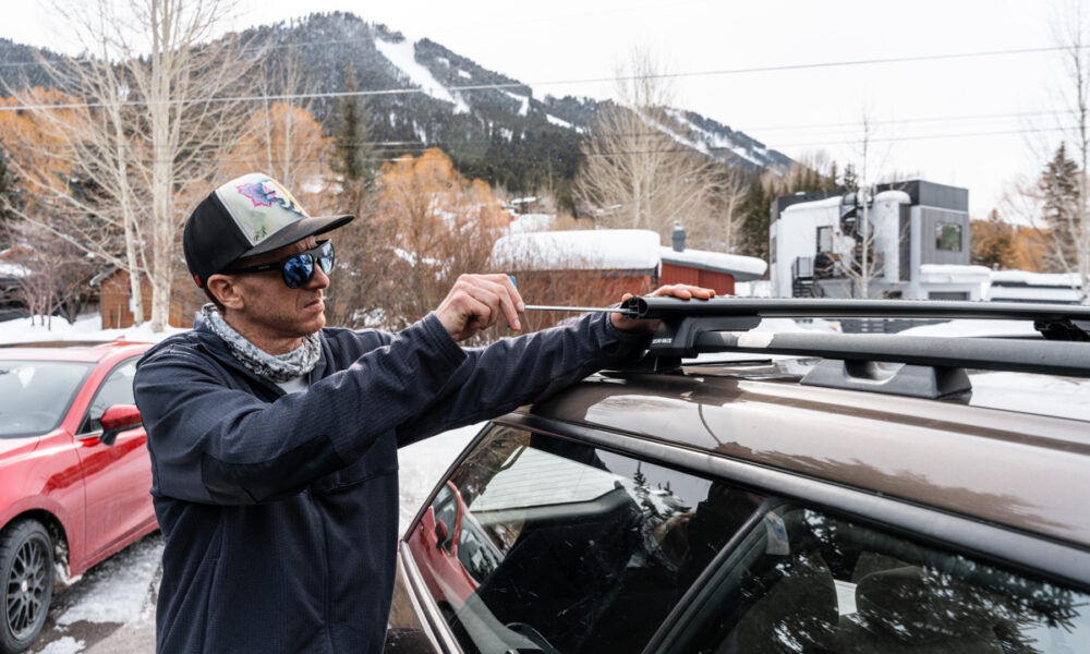 Man Installing Roof Rack Railing System for Automobile