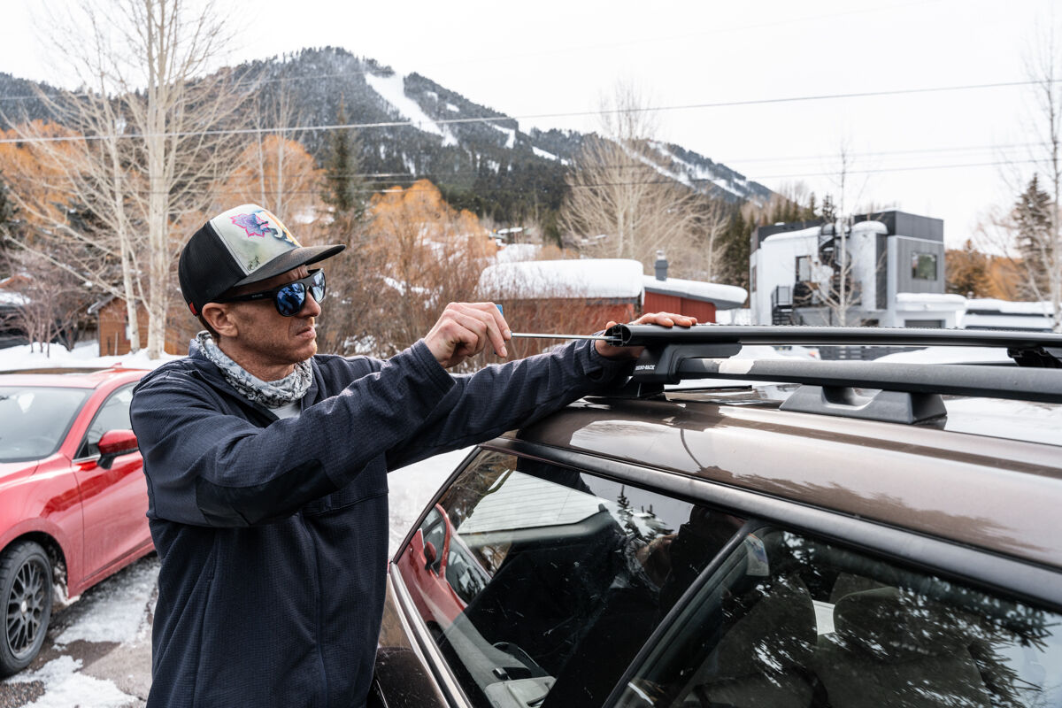 Man Installing Roof Rack Railing System for Automobile