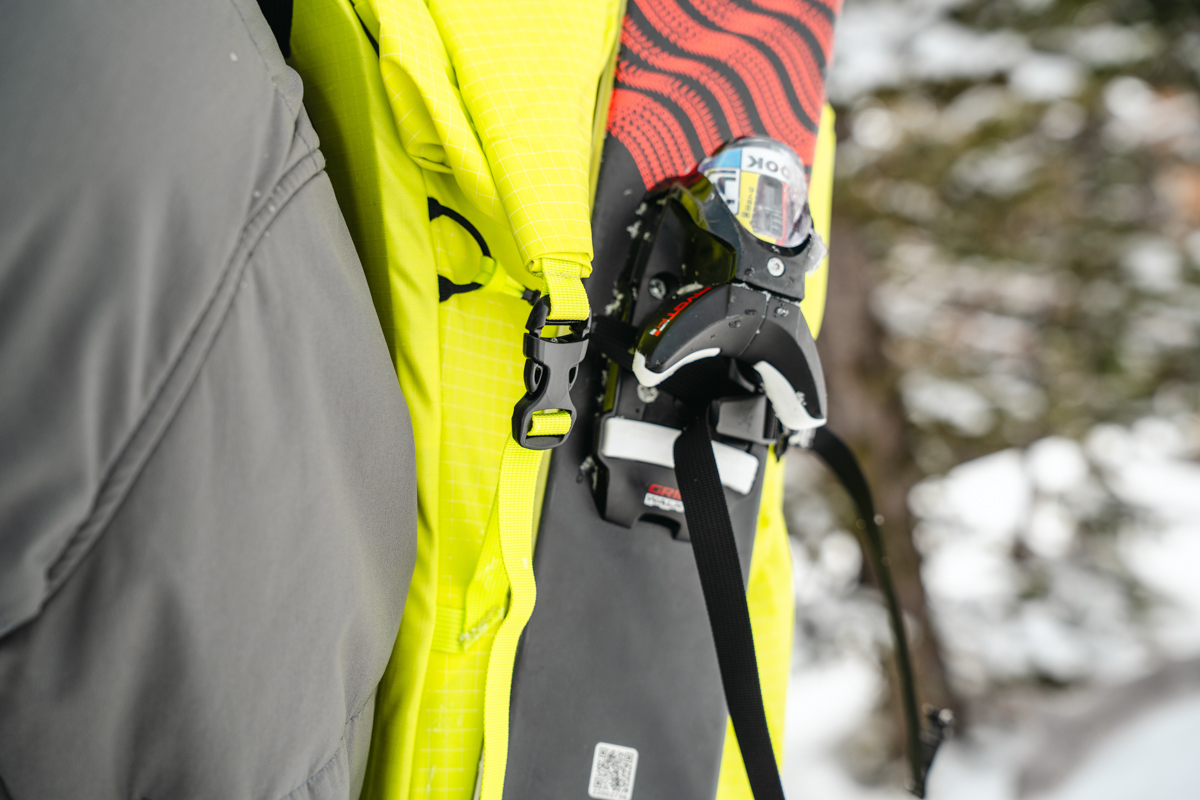 Man Carrying Skis on Backpack