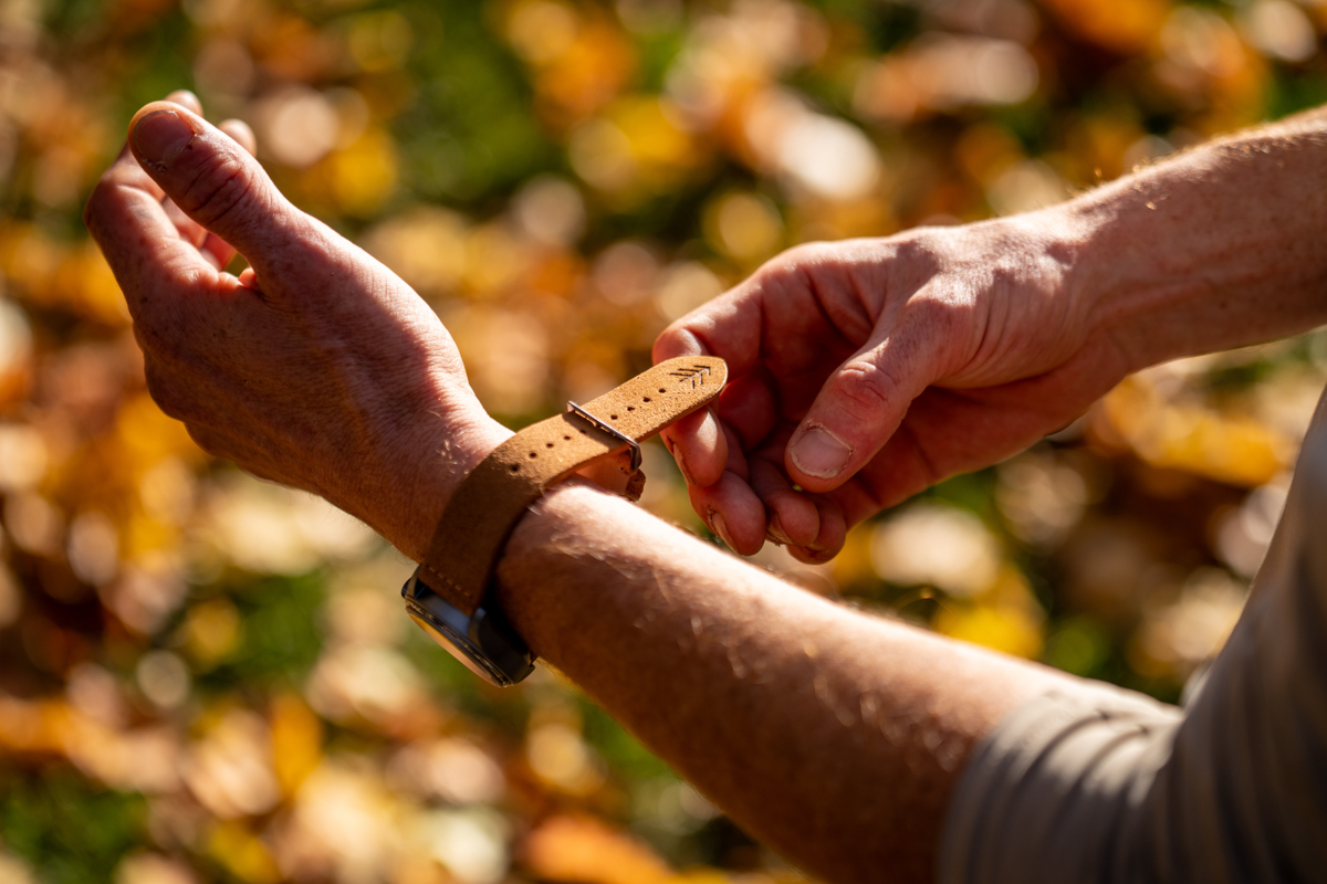 Man Putting on Leather Band Watch