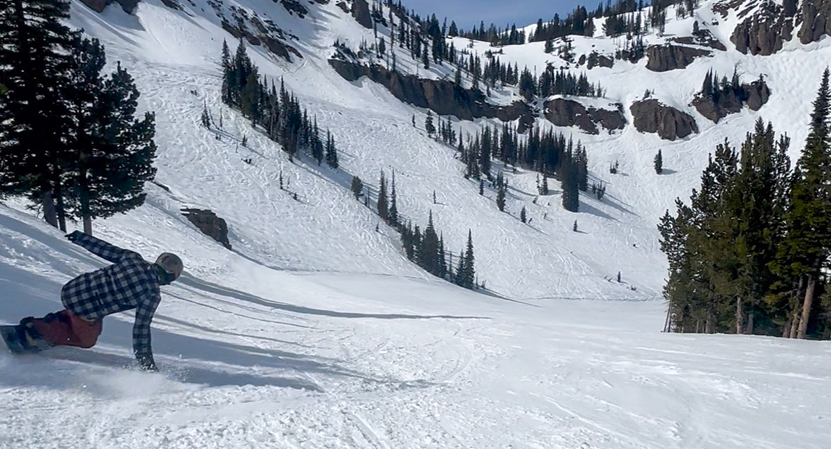 2027 K2 Commonwealth Snowboard carving through deep powder and variable terrain at Jackson Hole Mountain Resort.