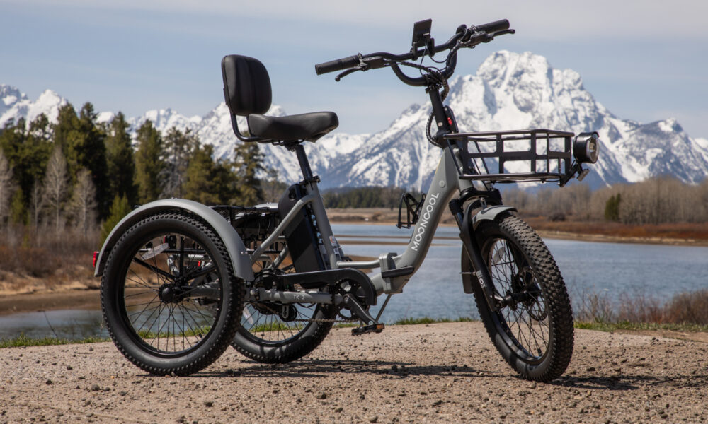 Full side profile of the Slate Gray Mooncool TK2 folding electric trike on a dirt path.