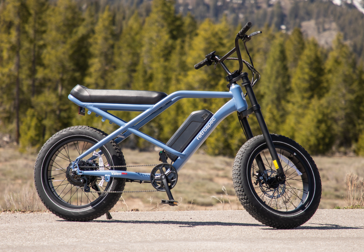 Retrospec Valen Rev 3 E-Bike in Blue Against Green Trees
