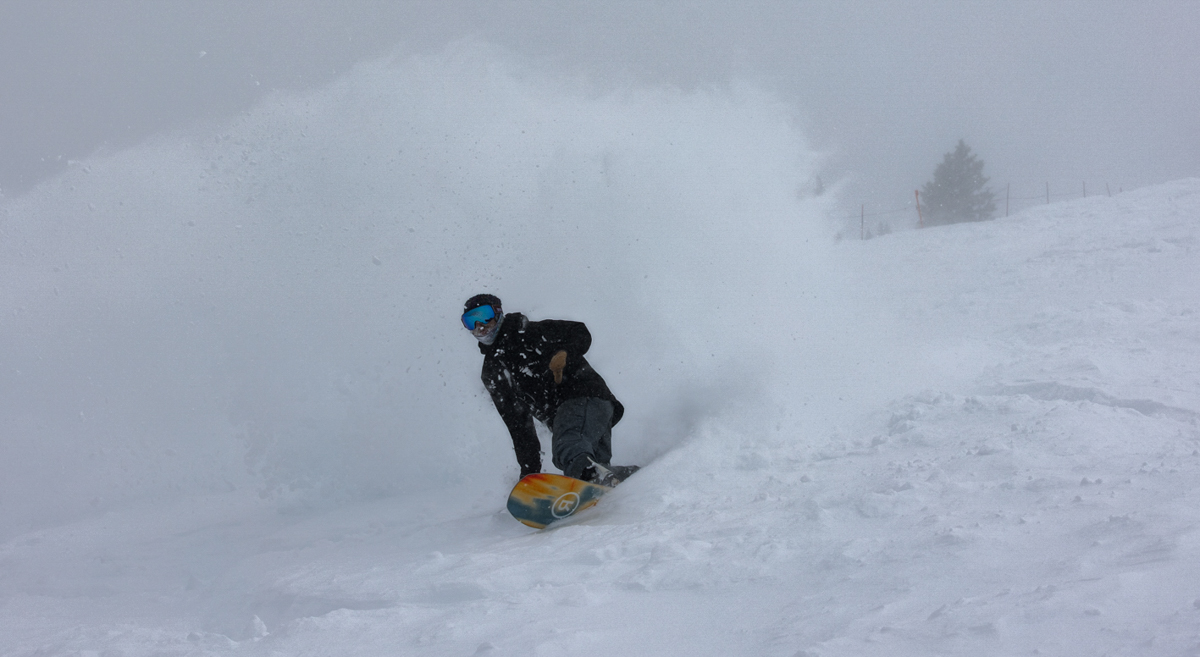 Man Ripping Snowboard Turn on Ride Snowboard