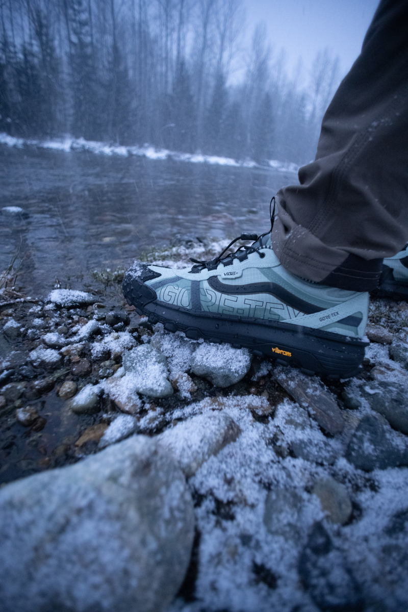 Side profile of Vans MTE Crosspath XC GORE-TEX shoe on wet river rocks to demonstrate waterproofing.