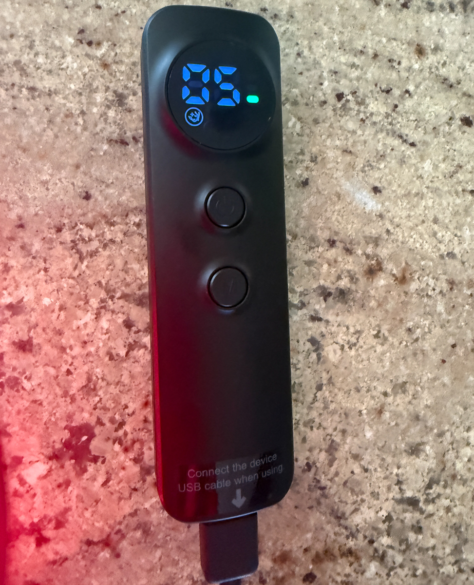 Hand holding the EZ-Life red light therapy mask remote controller showing 5-minute time