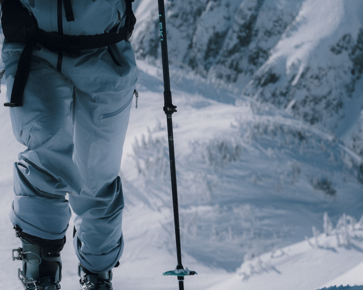 Close-up of Patagonia Women's PowSlayer Pants showing the reinforced scuff guards and watertight side vent zippers, demonstrating durability for high-output backcountry touring