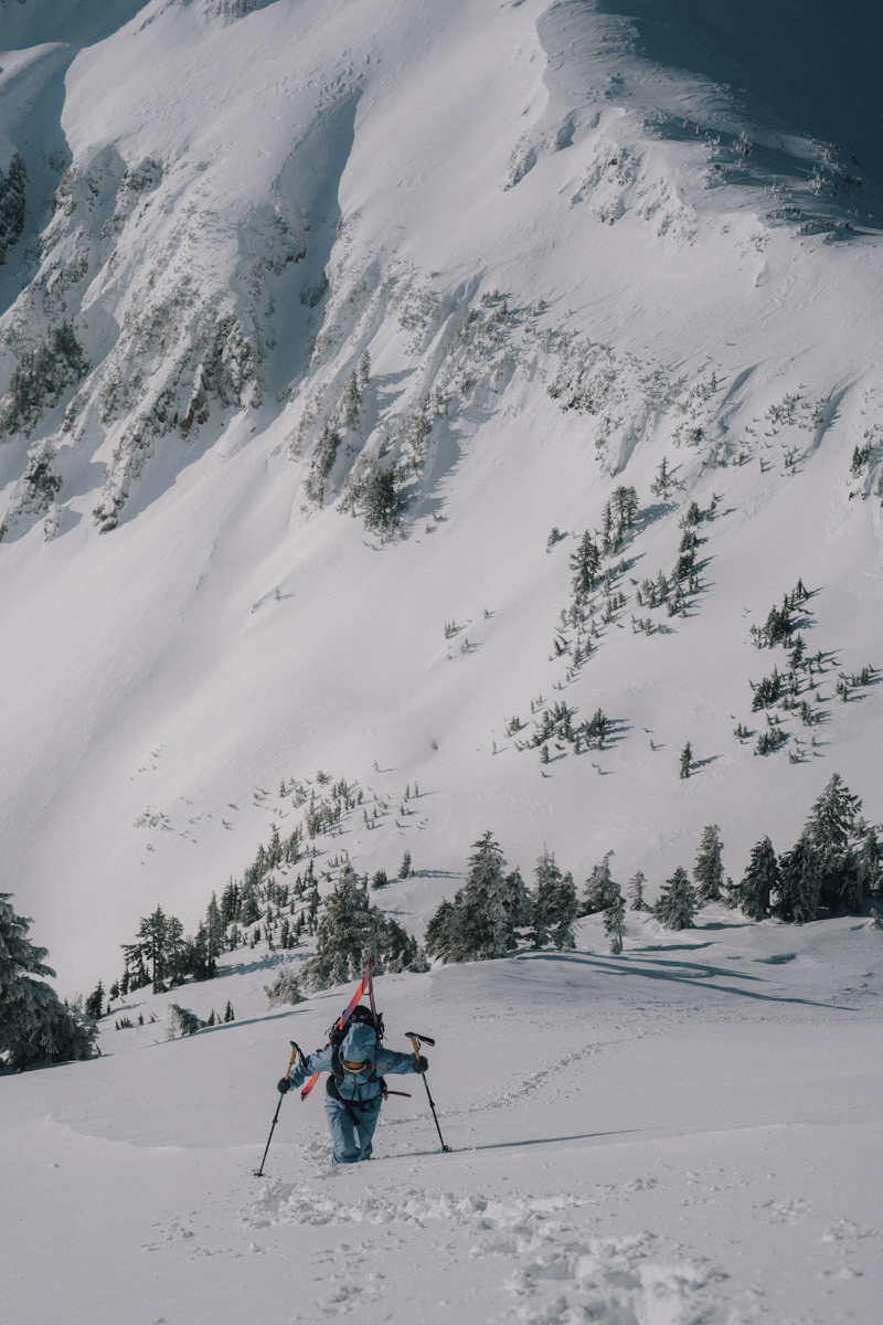 Skier navigating steep, deep bootpack in Patagonia Women's PowSlayer Pants, showcasing the relaxed fit and articulation for technical mountain ascents.