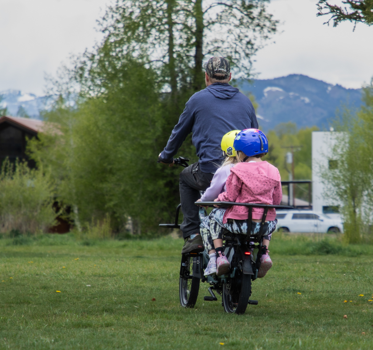 Eric Odlin rides away on the Xtracycle Hopper E-Bike with his daughters in the rear cargo area in Jackson Hole, WY.