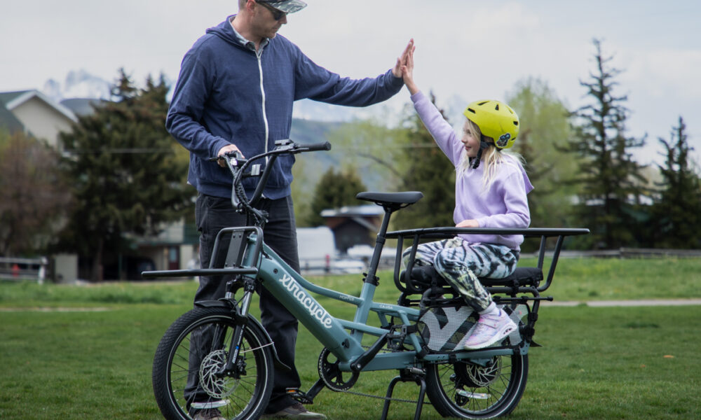 Eric Odlin high fives his daughter beside the Xtracycle Hopper E-Bike during family testing in Jackson Hole, WY.