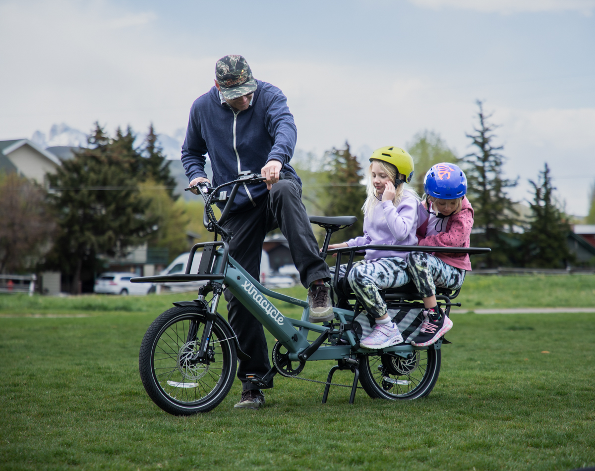 Eric Odlin gets ready to ride the Xtracycle Hopper E-Bike with his daughters seated in the rear cargo area in Jackson Hole, WY.