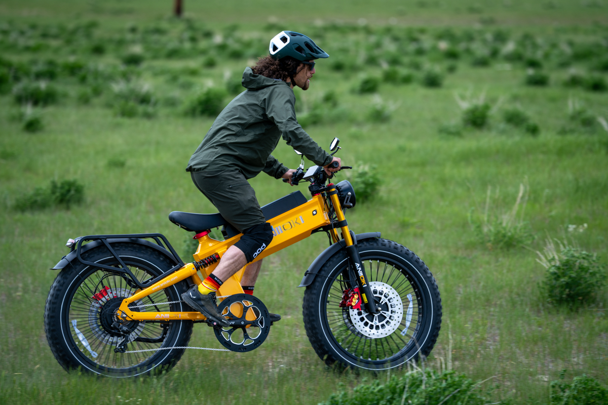 Pat Kinney riding the Aniioki A9 Pro Max e-bike across open grasslands near Jackson Hole with the Teton Range visible in the distance during TETON Tested field testing.