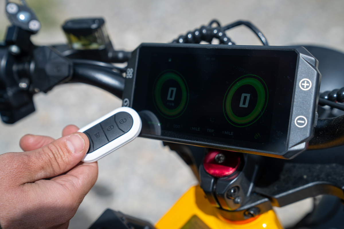 Close-up of the Aniioki A9 Pro Max key fob and multifunction display showing the bike's security and technology features.