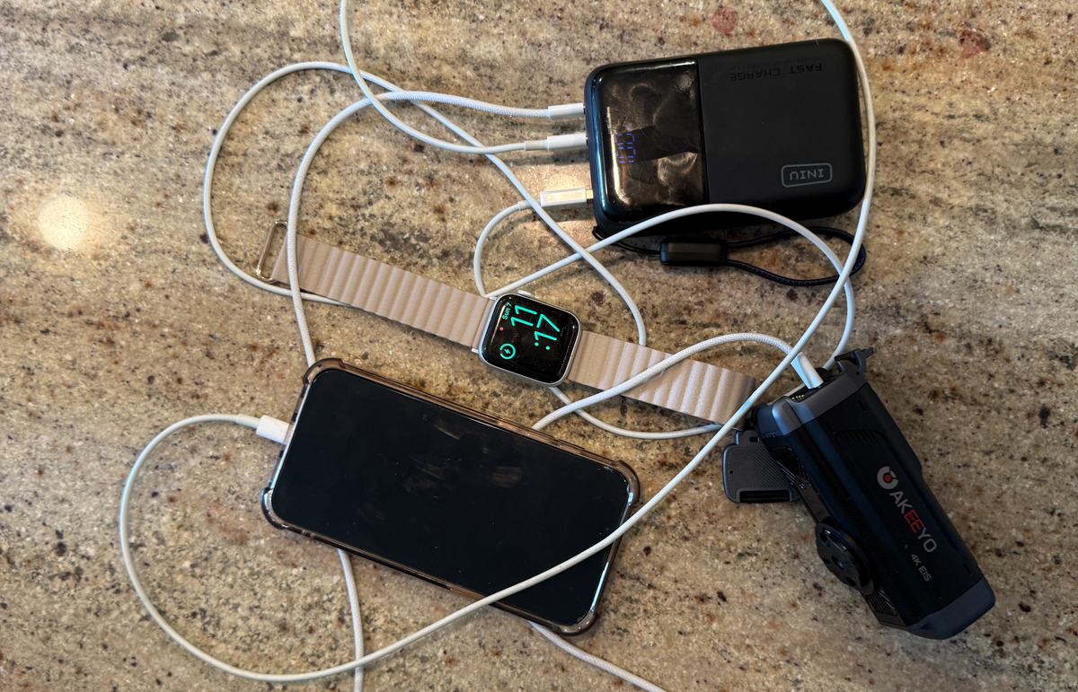 INIU Cougar P63 battery pack charging a phone and accessories on a countertop.
