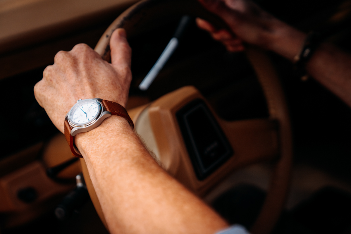 Mike Hardaker wearing the VERO x Wildwood Studio Edition stainless steel watch while driving the Grizzly Woody in Jackson Hole, Wyoming. The timeless automatic watch pairs classic design with everyday durability, equally at home behind the wheel of a vintage Grand Wagoneer or in a modern boardroom. | Photo Griffin Kerwin Mountain Weekly News